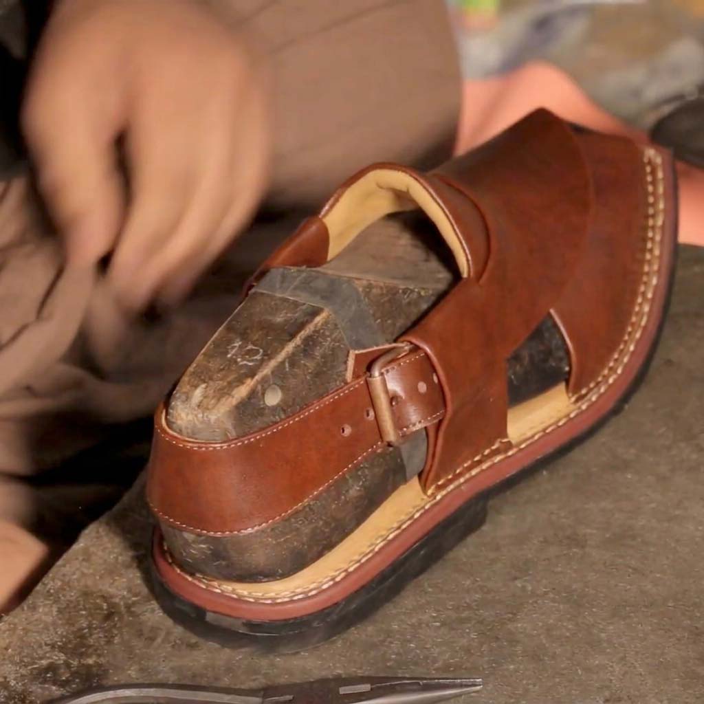 A fully assembled Bera premium leather sandal resting on a traditional wooden last for architectural shaping and ergonomic contouring.