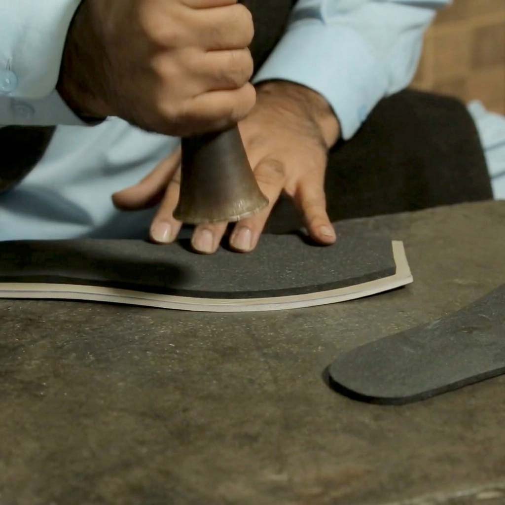 Master artisan meticulously integrating and pressing high-density memory foam padding into the sole of Bera luxury footwear for maximum comfort.