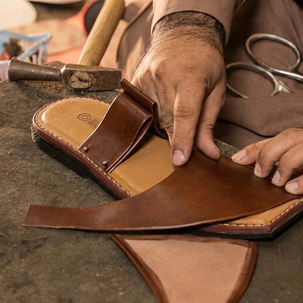 Master craftsman meticulously aligning and attaching the premium brown leather upper to the multi-layered sole of a Bera luxury handcrafted sandal.